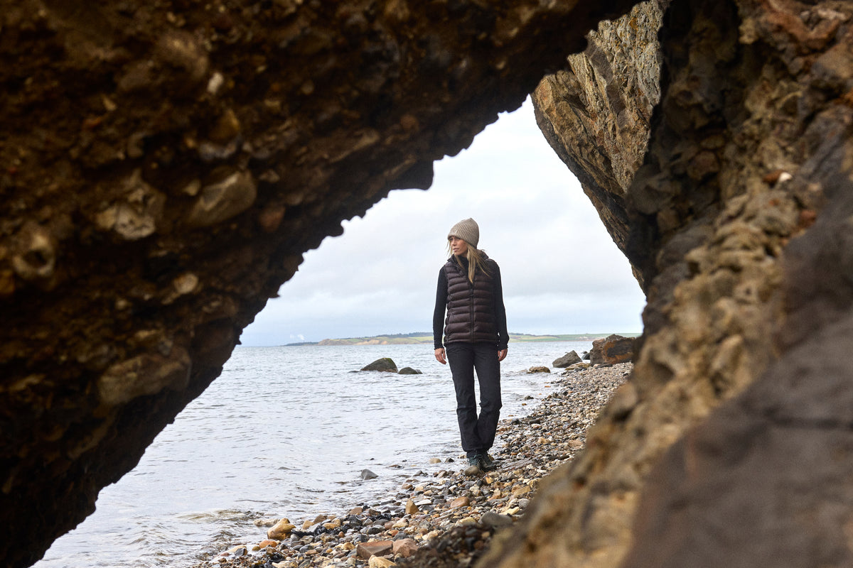 Woman wearing Nordisk Companyon in a rock cave on the coast