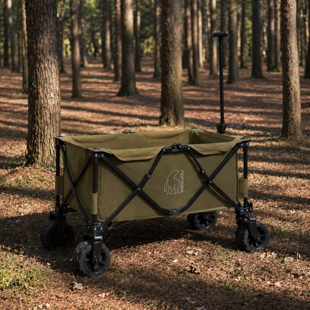 Green folding wagon with black frame in a forest setting