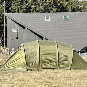 Green tent in front of a building with a logo on a clear day