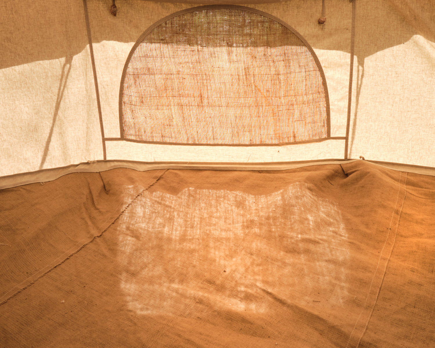 Close-up of a beige tent interior with a mesh window.