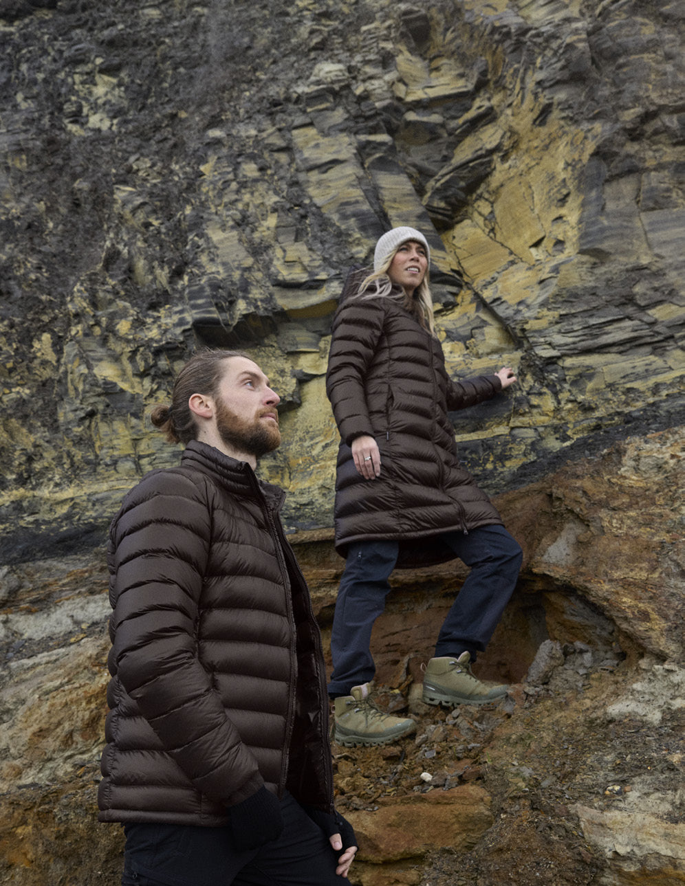 Man in the Companyon Hjalte down jacket and woman in the Companyon Dagmar down coat by a rock face